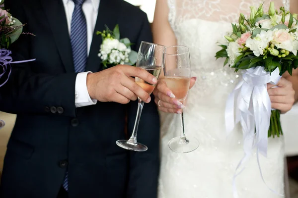 Nahaufnahme von frisch vermählten Händen, die Champagnerflöten klirren — Stockfoto