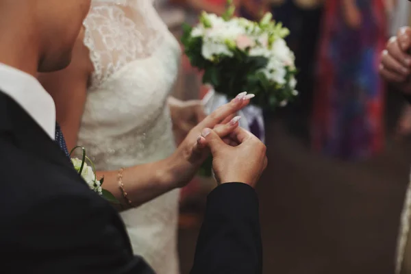 Наречений одягає весілля кільце нареченої пальцем під час церемонії — стокове фото