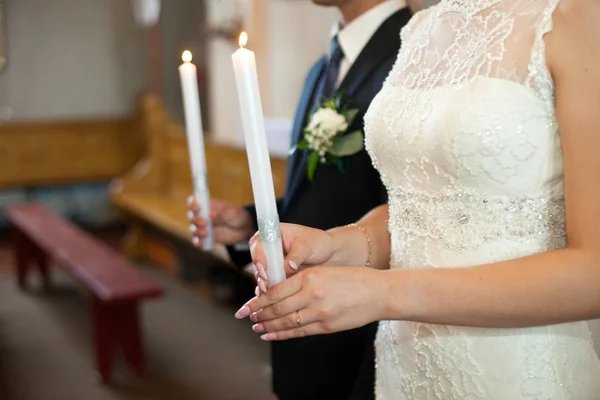 Наречена в мереживній сукні тримає білу палаючу свічку — стокове фото