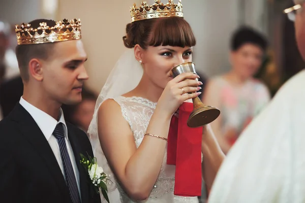 Noiva olha para um pries bebendo vinho sagrado — Fotografia de Stock