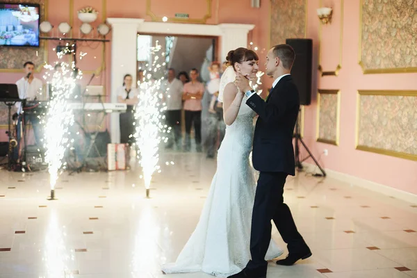 Brudgummen danser med en garcious brud i vita restaurang hall — Stockfoto