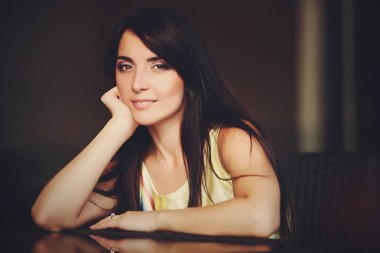 Güzel esmer Cam masada oturur