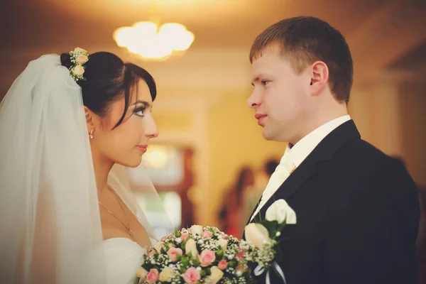 Braut und Bräutigam schauen einander aufmerksam an, wenn sie im H stehen. — Stockfoto