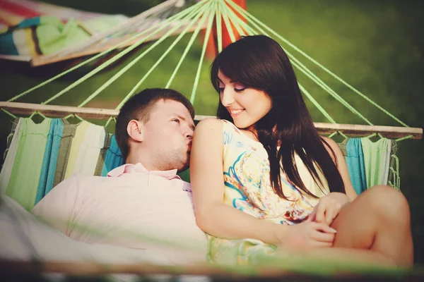 L'homme embrasse l'épaule de la femme couchée sur l'hamac — Photo