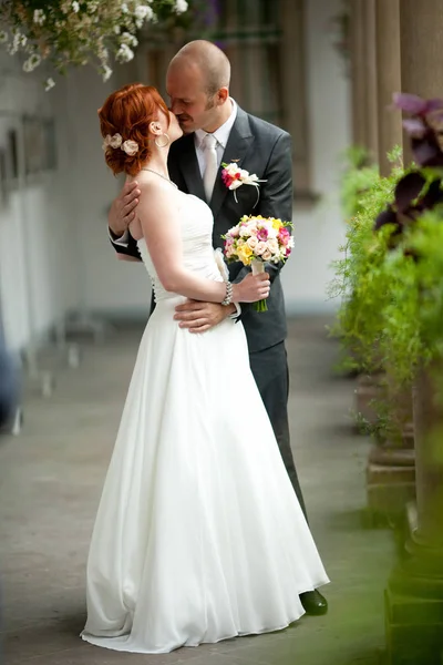 Bride looks over her shoulder while groom waits for her — Stock Photo, Image