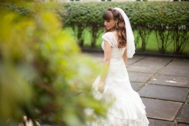 Uzun kıvırcık saçlı gelin görünüyor poz omzunun üzerinden