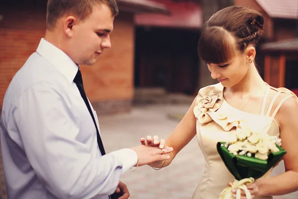 Mariée en robe beige met une alliance sur le doigt du marié — Photo