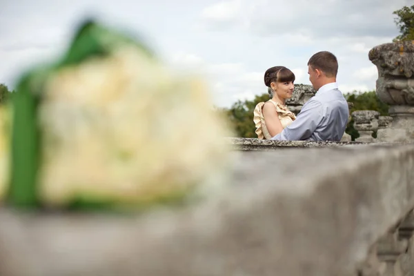 A look from behind the wedding bouquet on bride and groom standi — Stock Photo, Image