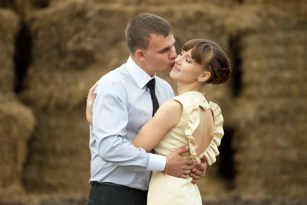 Man kussen dame in een Wang knuffelen haar betwenn haycocks — Stockfoto