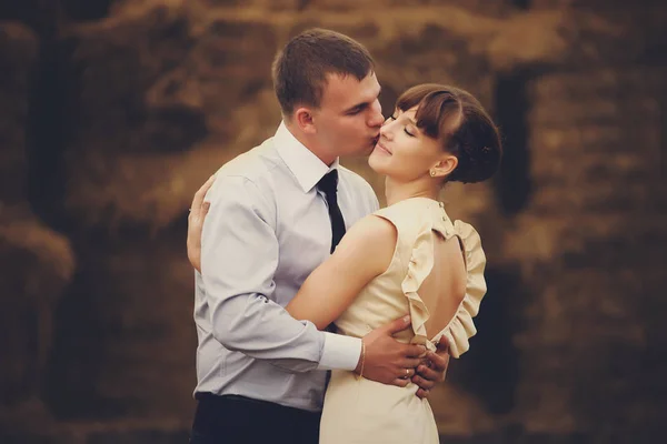 Gtoom küsst eine Frau, die zärtlich vor den Heuhähnen posiert — Stockfoto