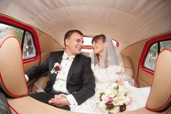Szczęśliwy ślub para siedzi w samochodzie z beżowym wnętrzem — Zdjęcie stockowe