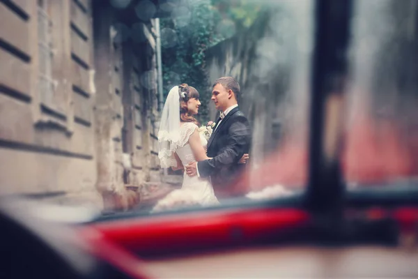 Blick aus dem Auto auf ein Hochzeitspaar, das draußen steht — Stockfoto