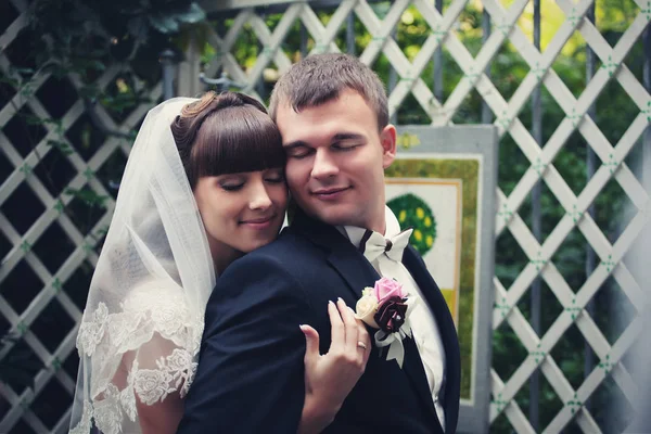 Wedding couple enjoys a moment hugging on the white porch — Stock Photo, Image