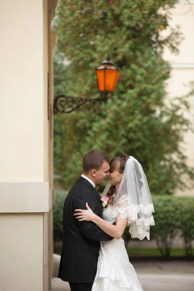 Glückliches Hochzeitspaar küsst sich unter der Laterne draußen — Stockfoto