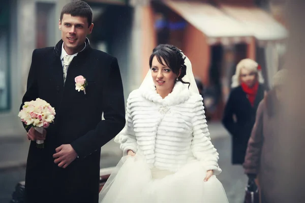 Novia y novio en abrigos de invierno caminar a lo largo de la vieja calle — Foto de Stock