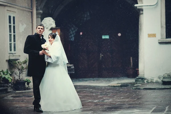 Beau couple de mariage se tient sur l'arrière-cour profitant de la sno — Photo