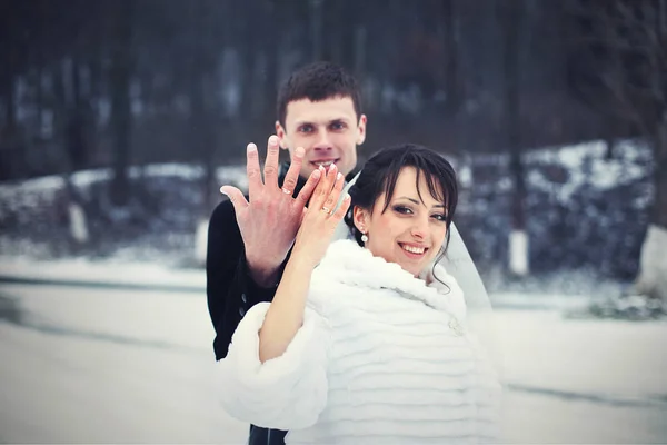 Casal de casamento feliz levanta as mãos com anéis de casamento de pé em — Fotografia de Stock