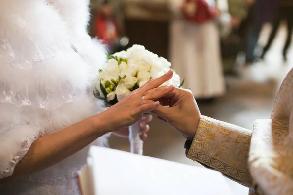Священник надевает обручальное кольцо на руки невесты во время церемонии — стоковое фото