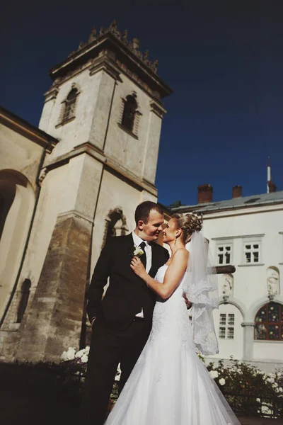 Una mirada desde abajo en la feliz pareja de boda posando en la fron — Foto de Stock