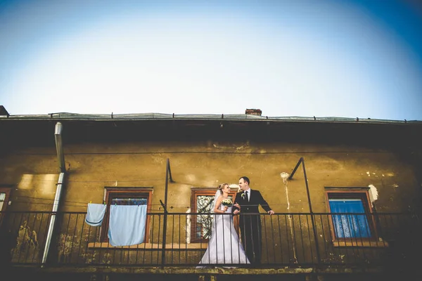 Nevěsta a ženich stojí, mluví na staré balkonu — Stock fotografie