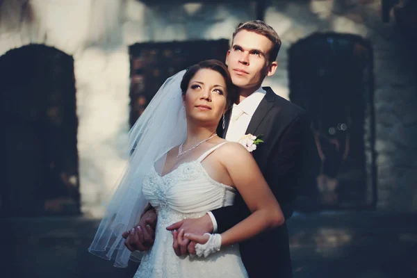 O sol brilha sobre os rostos dos recém-casados enquanto eles olham para o céu — Fotografia de Stock