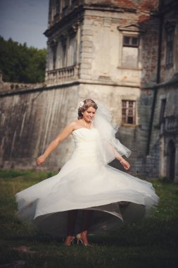 Sarışın gelin fırtınası bir kale önünde yeşil çimenlerin üzerinde