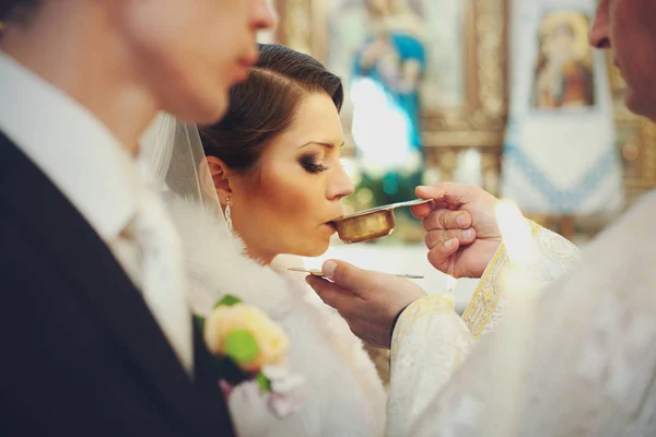 La novia bebe vino sagrado de las manos del sacerdote — Foto de Stock