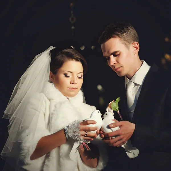 Прекрасная свадебная пара держит белых голубей позади друг друга — стоковое фото