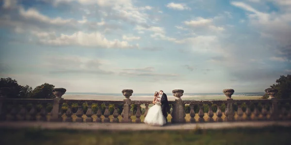 En stund innan en kyss av nygifta stående på gamla balkongen — Stockfoto