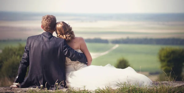 Um olhar por trás sobre os recém-casados desfrutando as belas terras — Fotografia de Stock