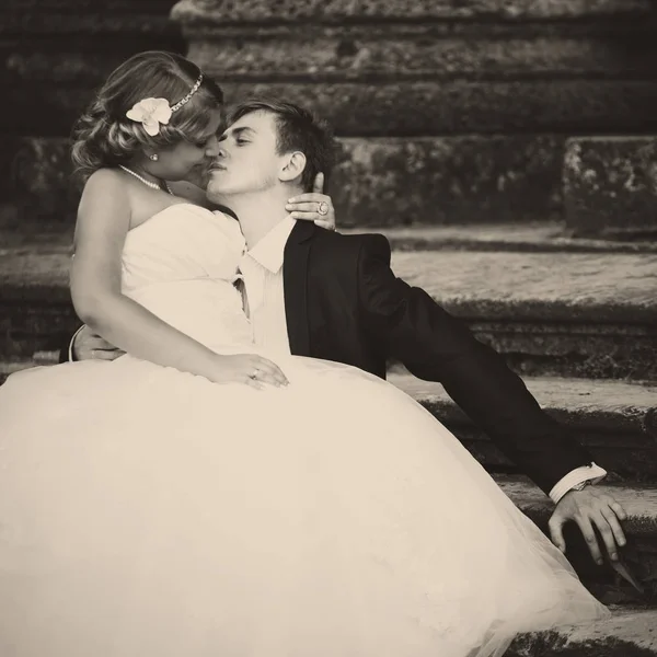 Noiva e noivo mentir sobre os velhos passos beijando — Fotografia de Stock