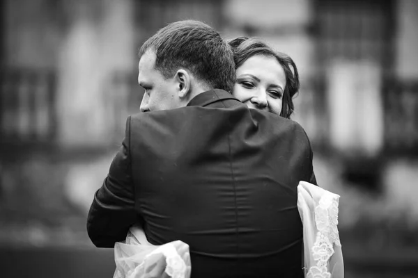 Sposa tenuta velo tra le mani abbracci sposo tenero — Foto Stock