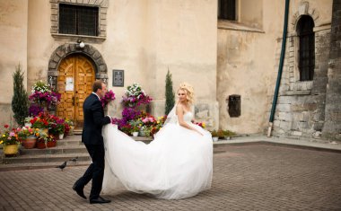 Onu düğün d tutan bir damat omzunda üzerine gelin görünüyor