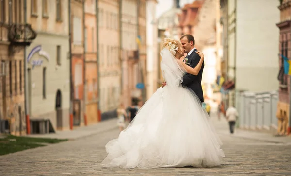 Prachtvolles Hochzeitspaar steht auf der leeren Straße — Stockfoto