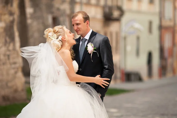 Bionda sposa ride in piedi dietro un serio sposo — Foto Stock