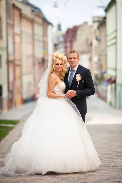 Gazdag esküvői pár áll az utcán tartja egymás kezét — Stock Fotó