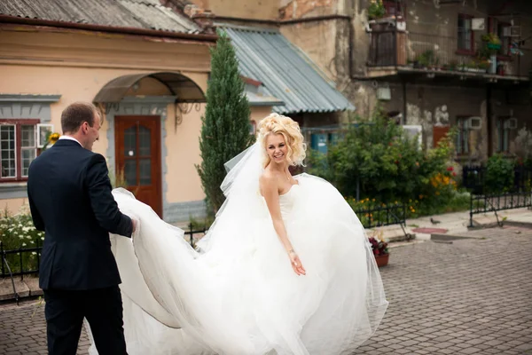 Yeni evliler CI yürüyüş yaparken damat bir cüppe tren tutar — Stok fotoğraf