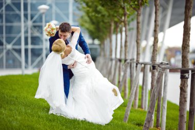 Damat muhteşem gelin yeşil çim üzerinde eğilir.