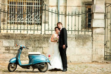 Tatlı çift mavi bir scooter arkasındaki sokakta duruyor