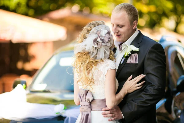 Bräutigam spricht mit einer Braut mit Blumen und Schleifen im Haar — Stockfoto