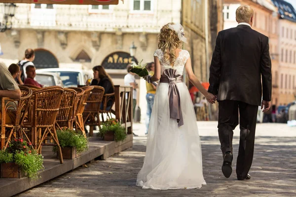 Ein Blick von hinten auf eine winzige blonde Braut im Kleid mit violettem Bo — Stockfoto