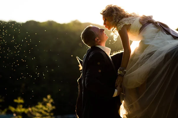 Sposa raggiunge il viso dello sposo per un bacio seduto sul cavallo in — Foto Stock