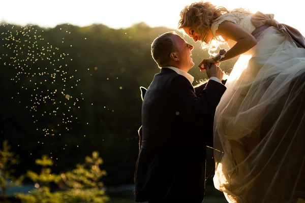 Sposo ride tenendo la mano della sposa mentre lei cavalca un cavallo — Foto Stock