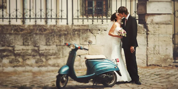 Édes pár csók, mögött a kék robogó egy üres utcán — Stock Fotó