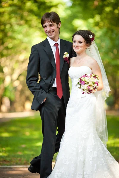 Sorridente sposo fiducioso sta dietro una bella sposa — Foto Stock