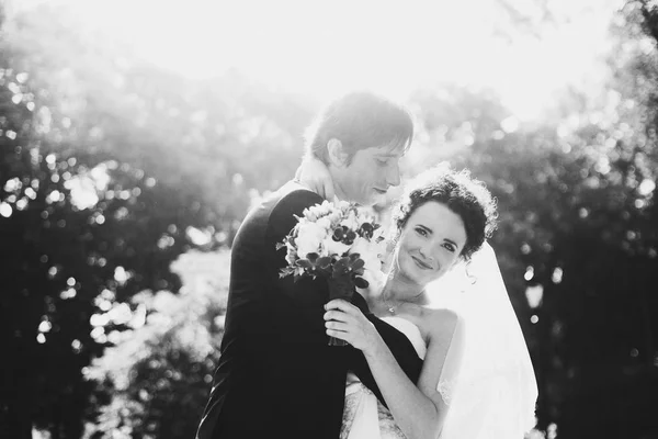 Retrato preto e branco de recém-casados em pé nos raios de su — Fotografia de Stock