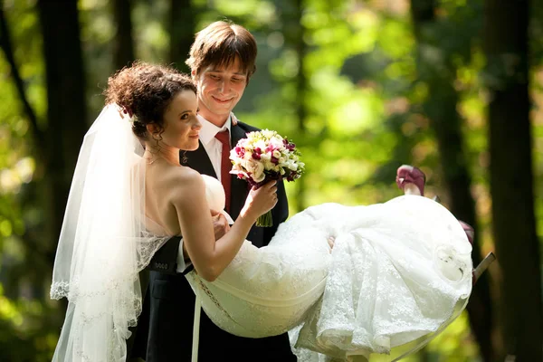 Fiance sourit sincèrement mariée charmante sur ses mains — Photo