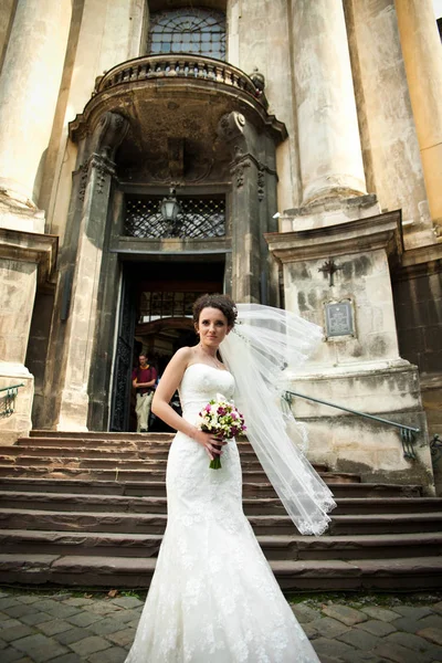 Vento soffia un velo di sposa riccia mentre lei sta dietro un entr — Foto Stock