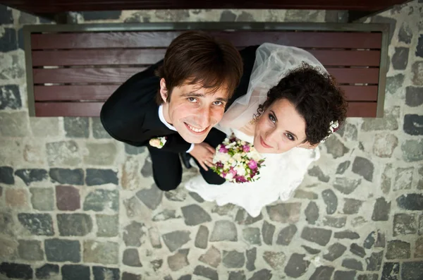 Blick von oben auf das hübsche Hochzeitspaar, das auf dem Boden sitzt — Stockfoto