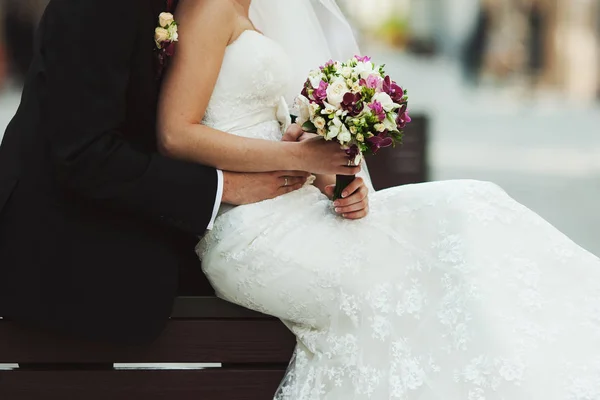 El novio sostiene la delicada cintura de la novia mientras ella miente sus manos con un —  Fotos de Stock